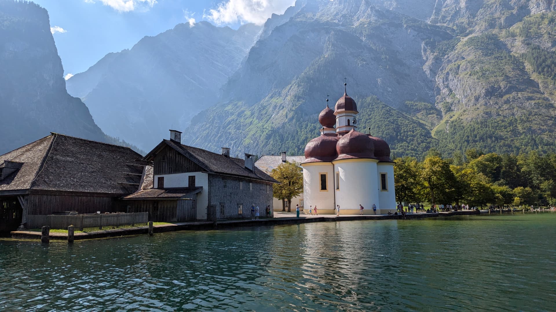 Die Kirche St. Bartholomä mit roter Zwiebelkuppel am Königssee, vom Boot aus gesehen, mit der Watzmann-Ostwand im Hintergrund.